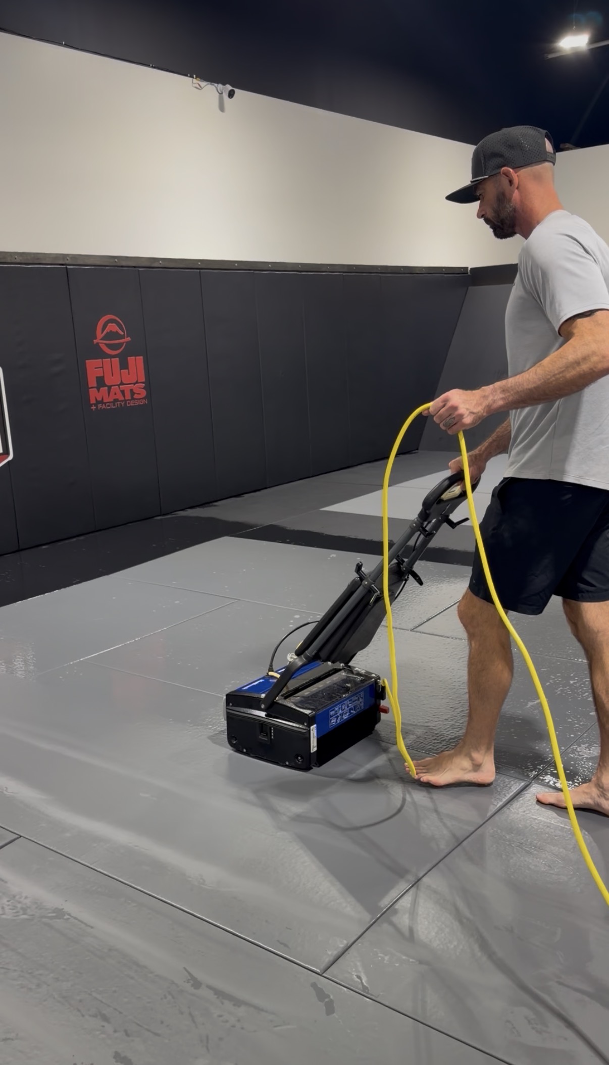 Mat Force technician cleaning gym mats with professional equipment